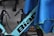 A section of a bicycle frame is partially covered by a blue cloth. The visible segment of the frame is labeled with the word 'Bian' and includes two black bottle holders attached. The surrounding area includes parts of a wheel and other cycling components, with some wires in the background.