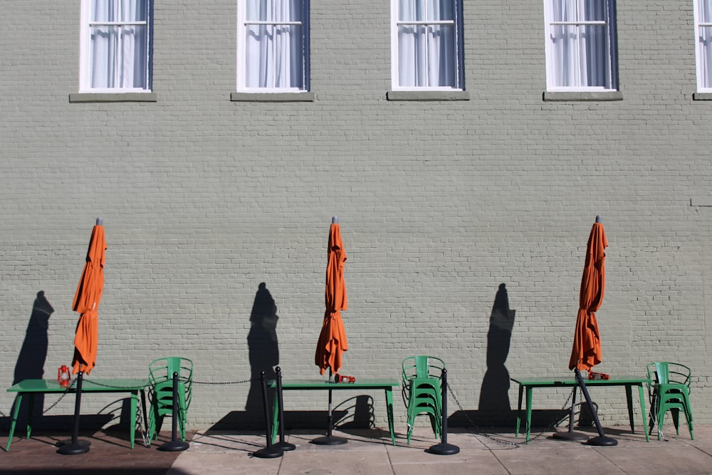 a group of tables and chairs with orange umbrellas