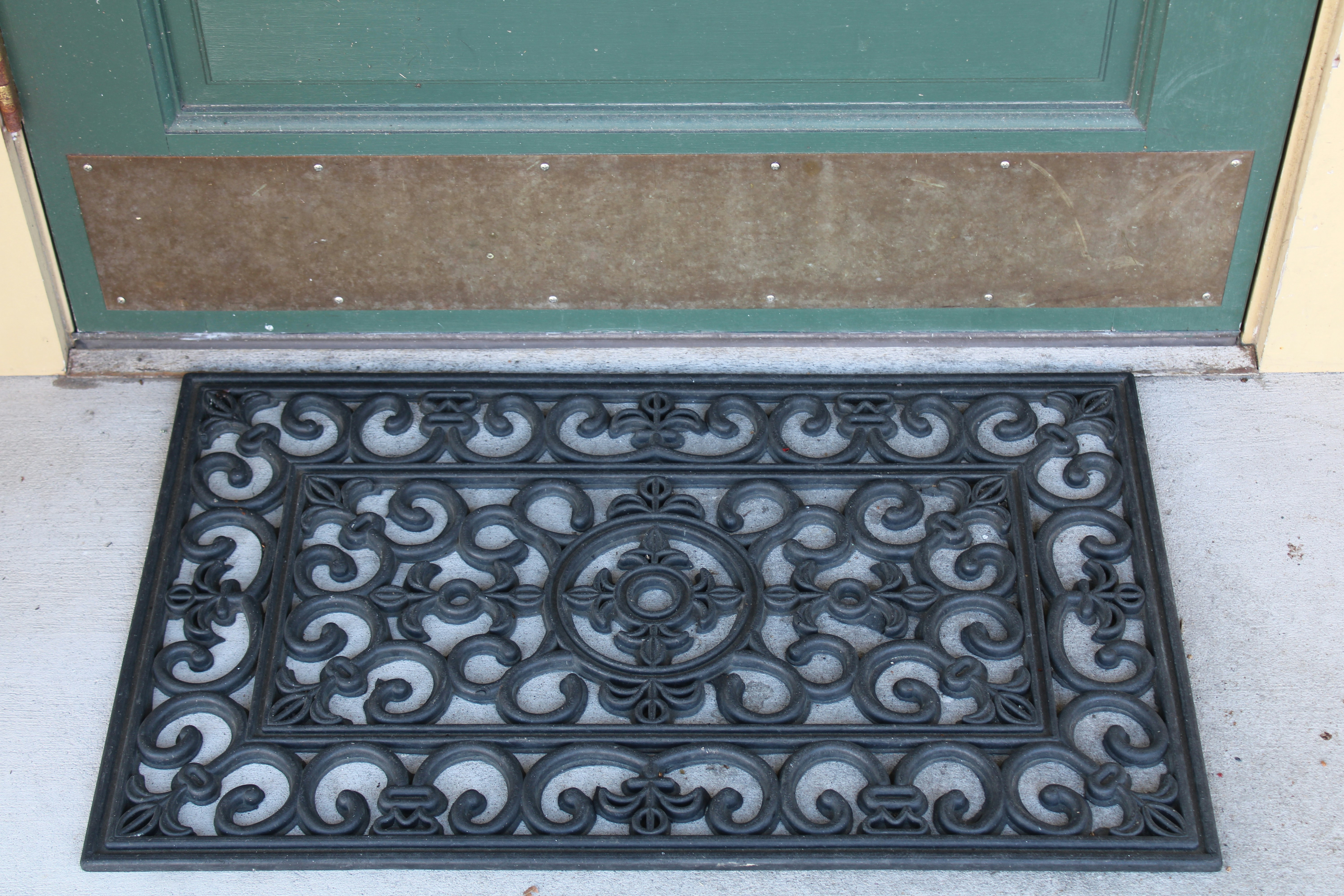 ドアの側面に座っている黒いドアマット