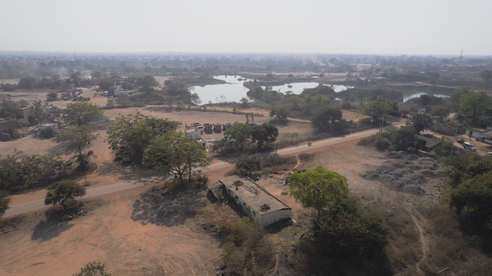 an aerial view of a dirt road and a lake