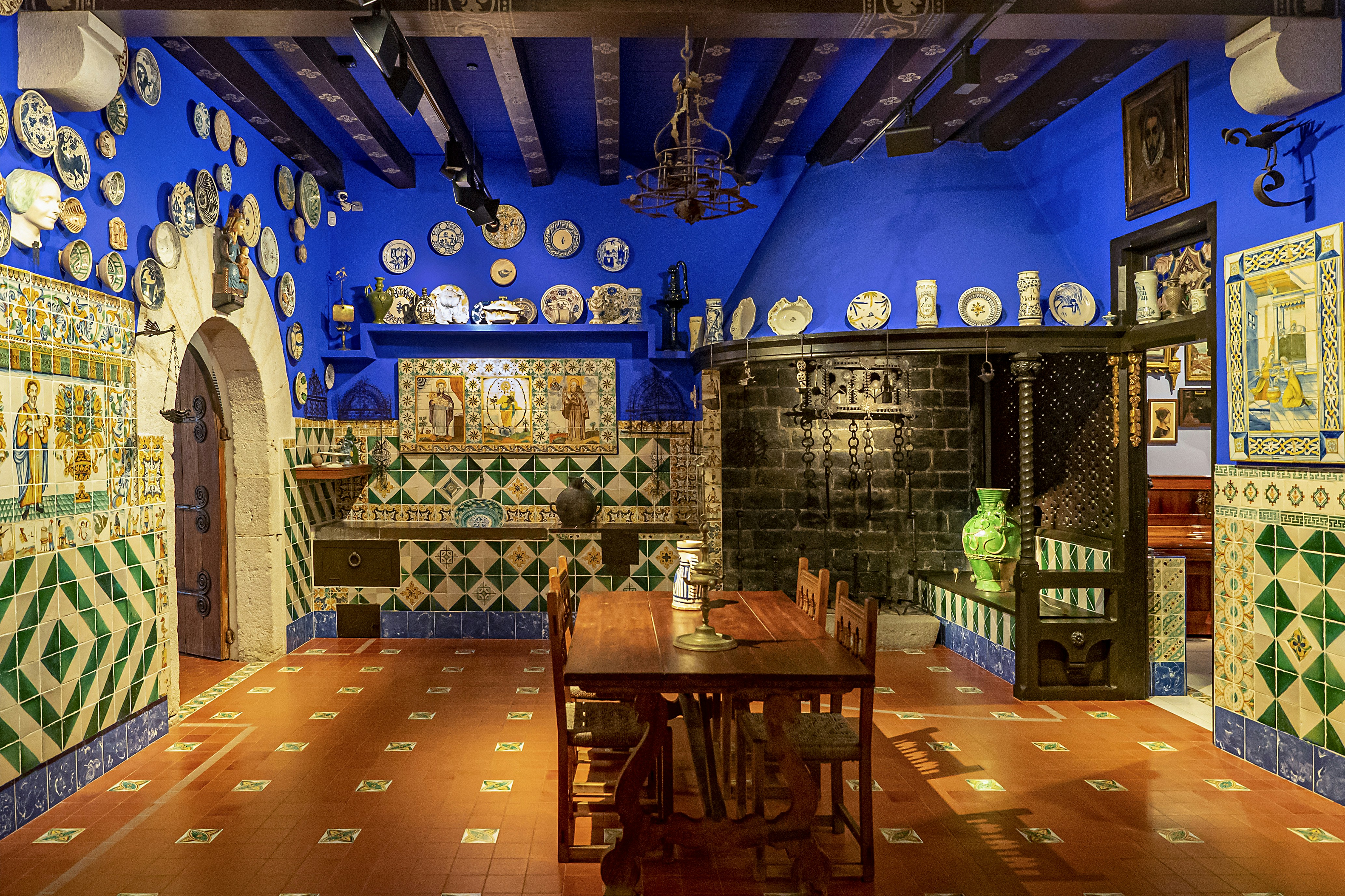 a dining room with a table and many plates on the wall