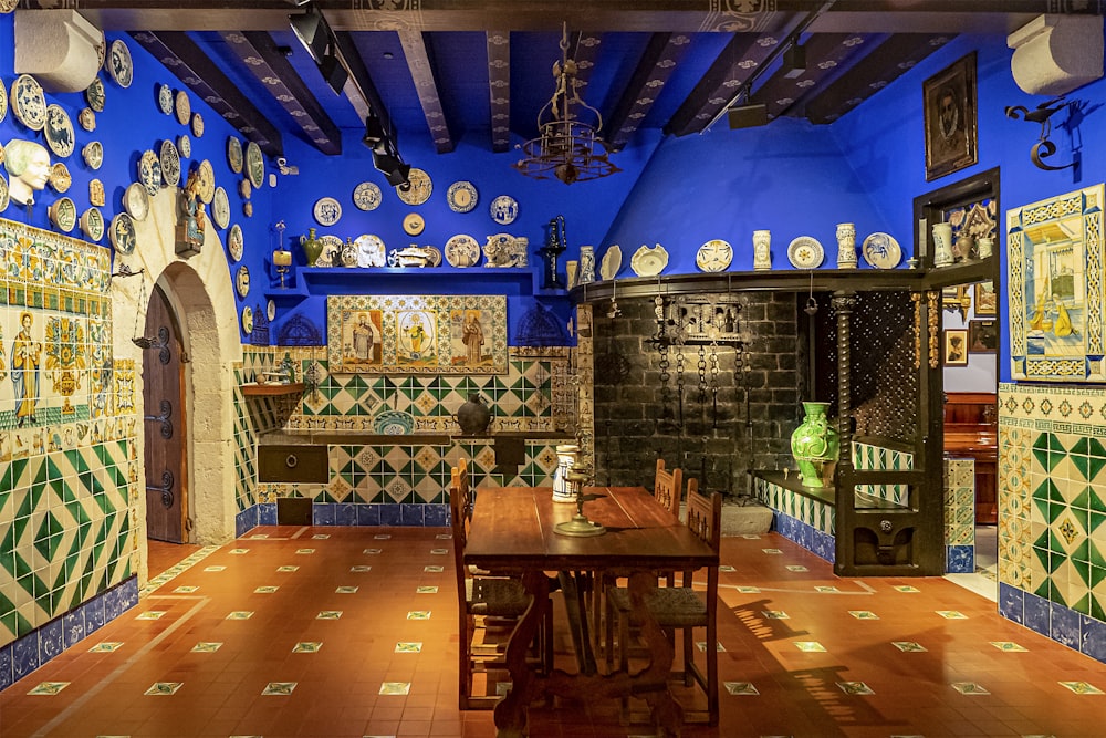 une salle à manger avec une table et de nombreuses assiettes au mur