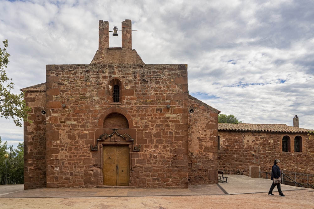 Un uomo che cammina davanti a una vecchia chiesa