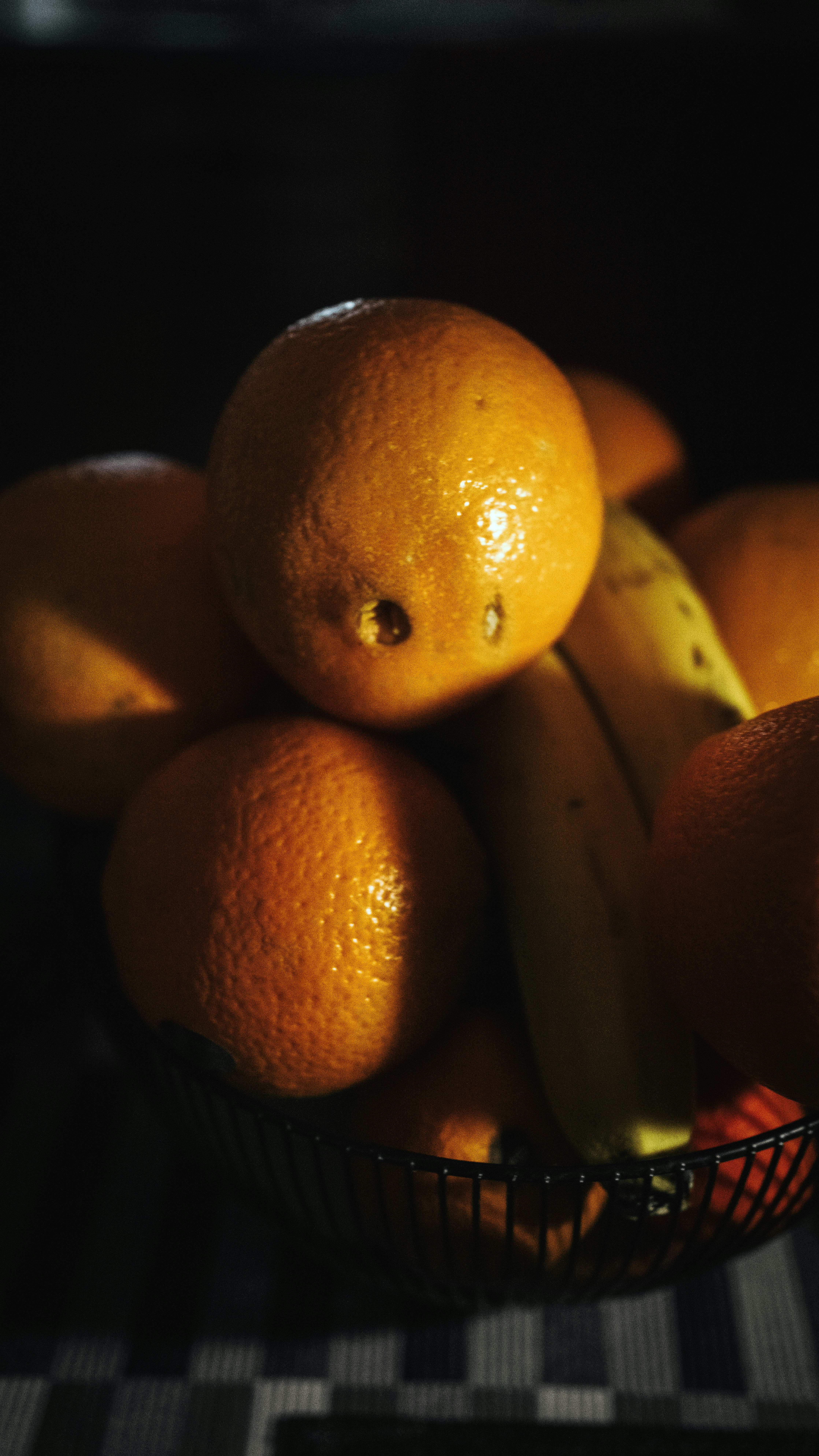 a bowl of oranges and bananas on a table