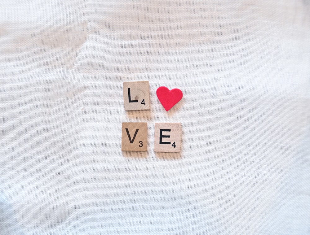 Scrabble Tiles Deletreando amor y un corazón rojo