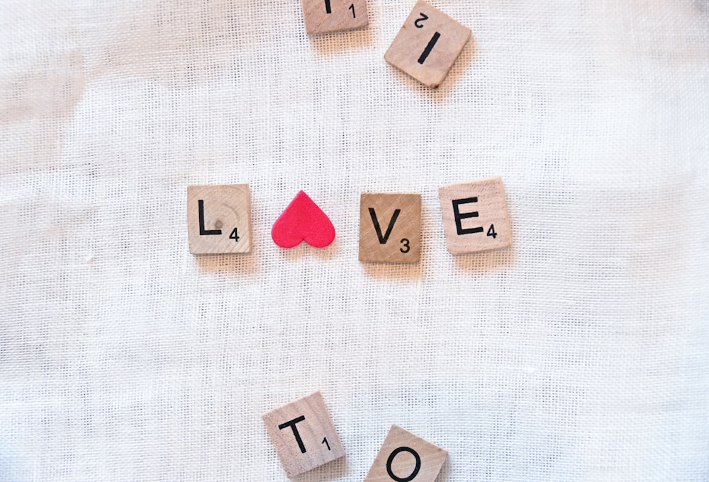 scrabble tiles spelling love and a red card