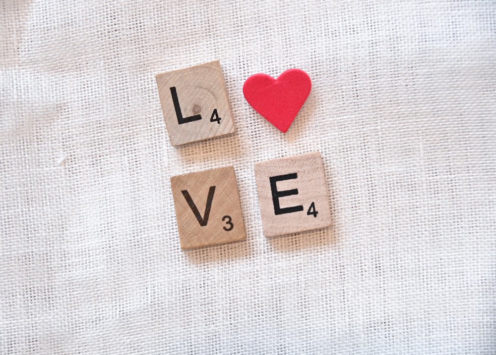 scrabble tiles spelling love with a red heart