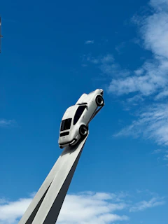 a white car on top of a tall pole