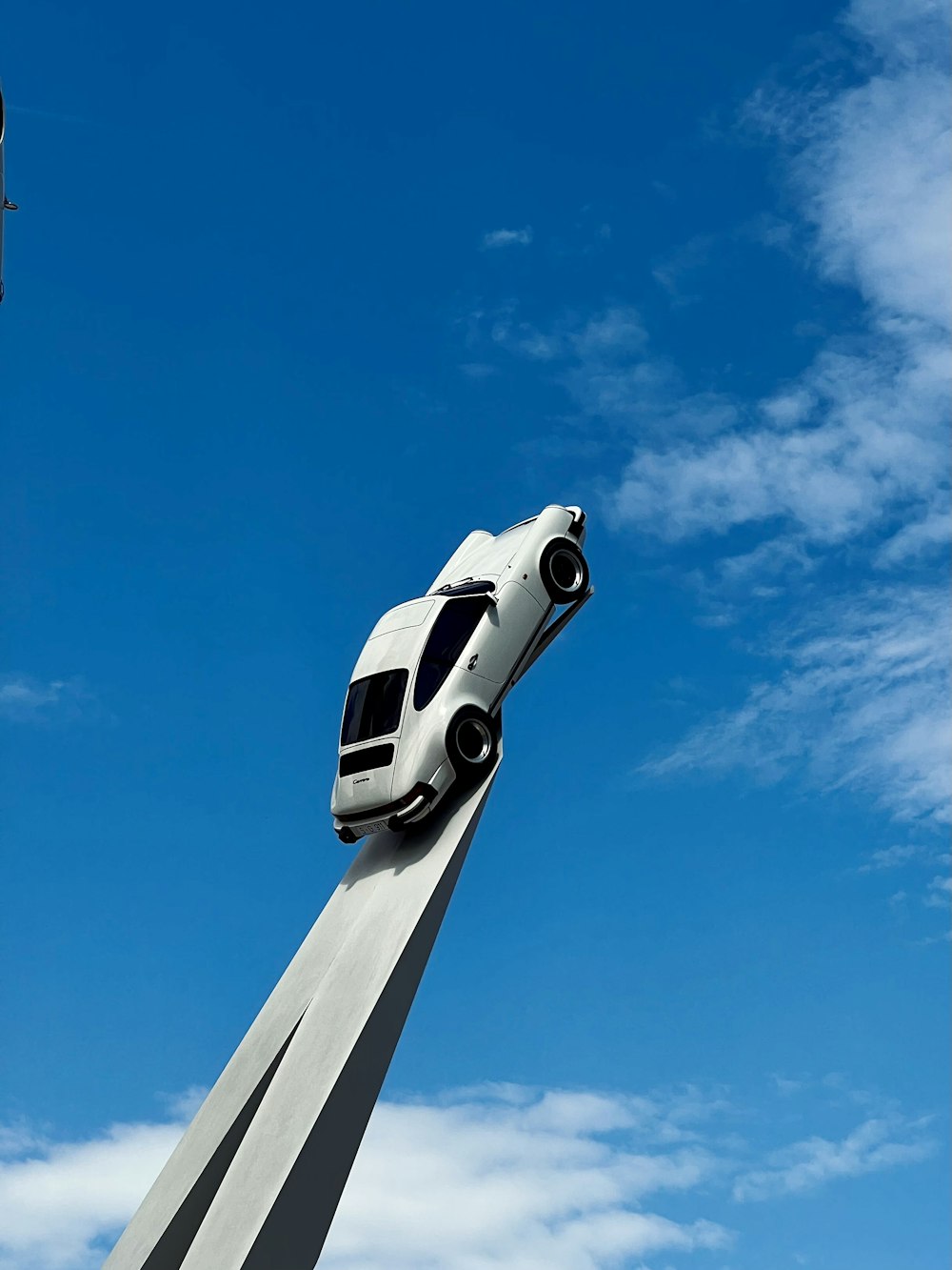 a white car on top of a tall pole