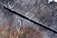 Close-up of textured wood-plastic composite decking with frost on the surface.