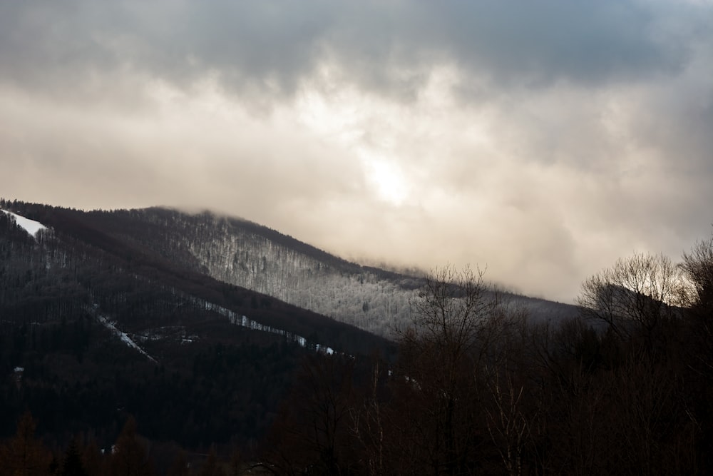 a mountain covered in snow under a cloudy sky