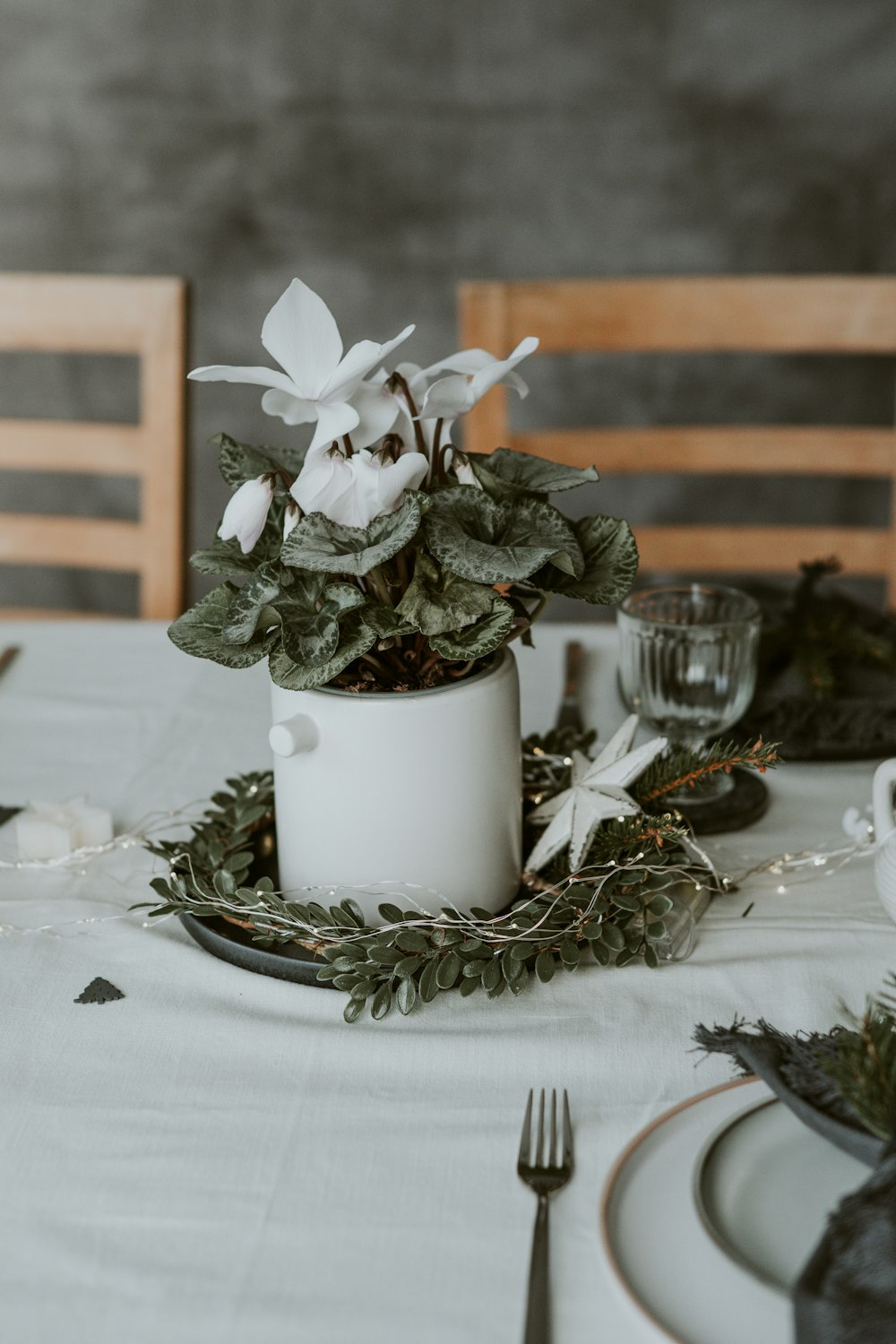 a table with a white table cloth and a white flower pot