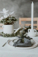 An intimate corporate event setup with minimalist table decor and muted eucalyptus green tones.