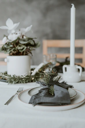 Minimalist corporate event setup with muted olive green accents and ivory tablecloths.