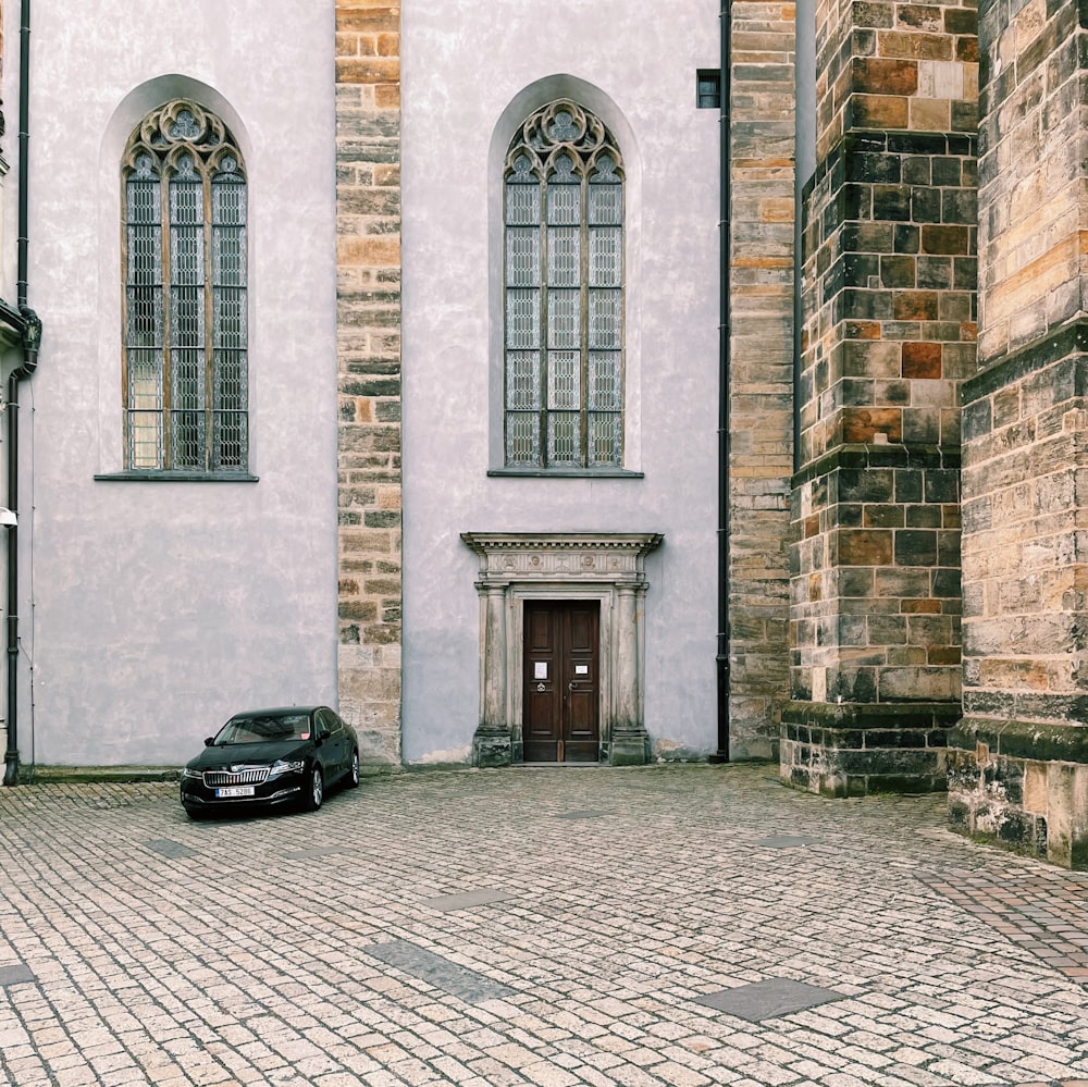 a black car parked in front of a white building