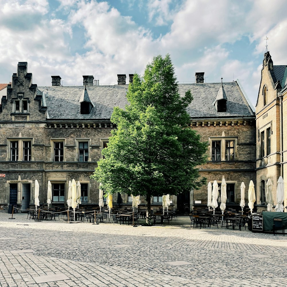 a large building with tables and chairs in front of it