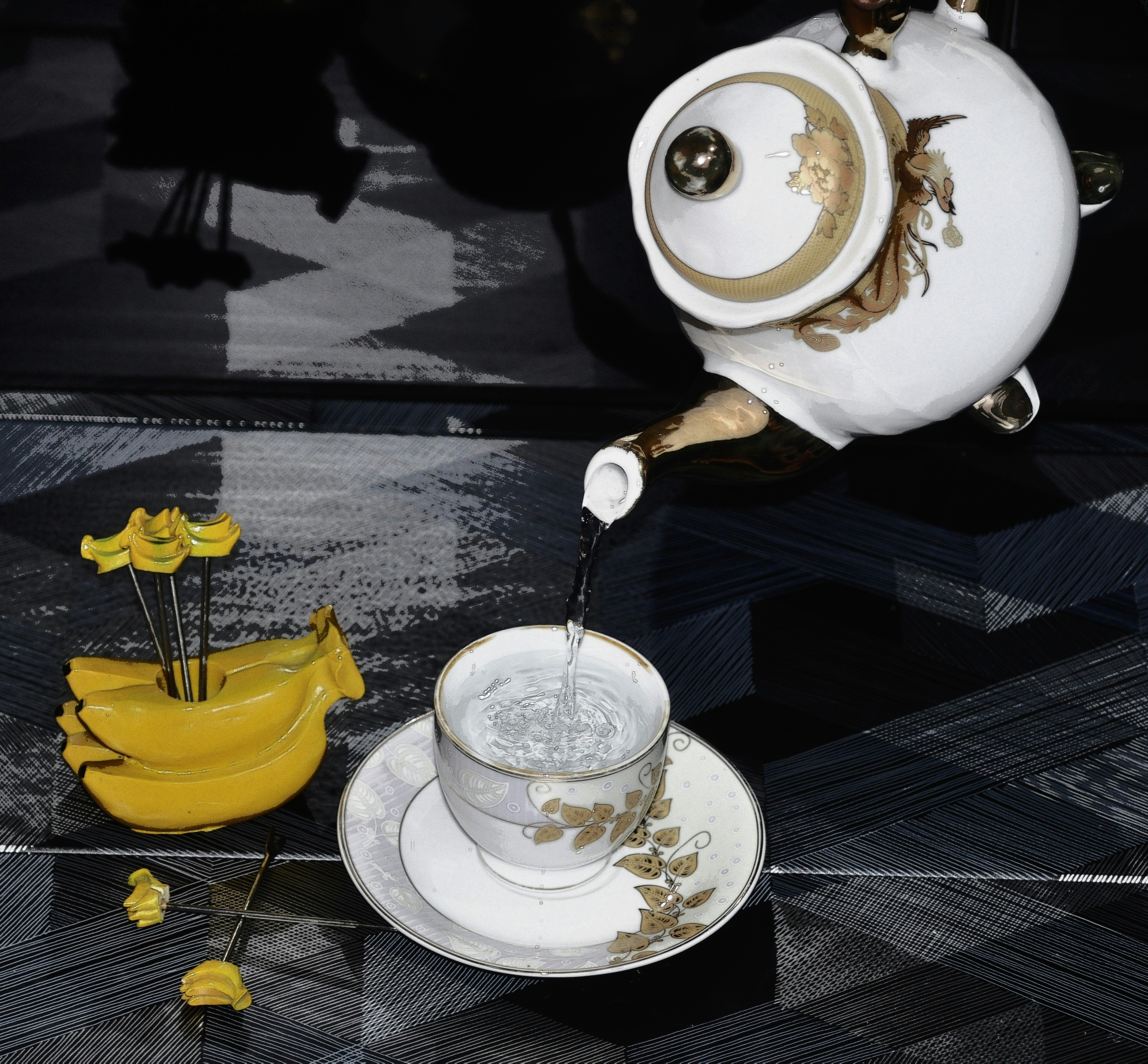 a tea pot pouring tea into a cup