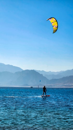 a man riding a surfboard on top of a body of water