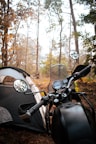 a motorcycle parked next to a tent in the woods