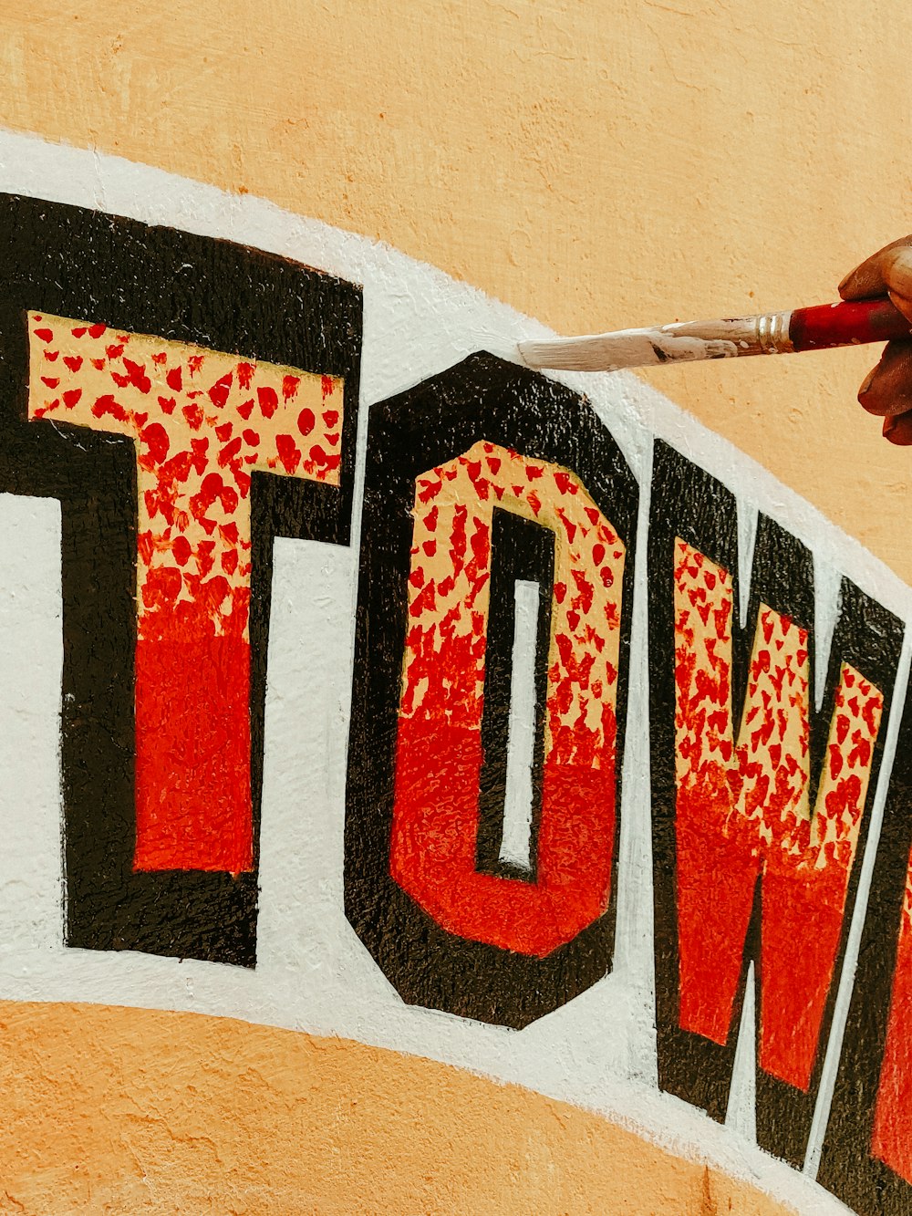 a person is painting the word town on the side of a building