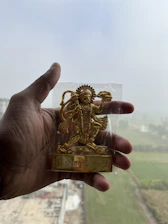 Close-up of a hand holding a Nakshatra Award plaque etched with cosmic symbols and gold accents.