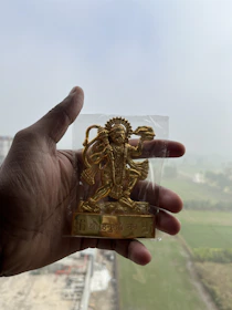 Close-up of a hand holding a Nakshatra Award plaque etched with cosmic symbols and gold accents.