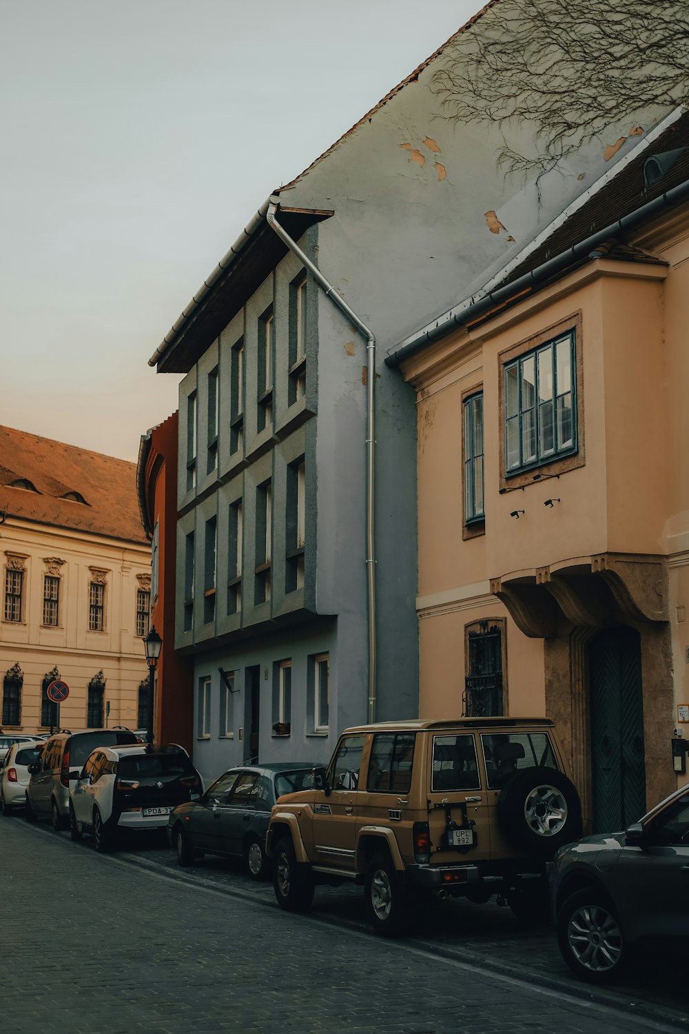 a row of parked cars on a street next to a building