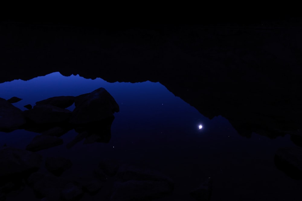 Una escena nocturna de una montaña con una luna en el cielo