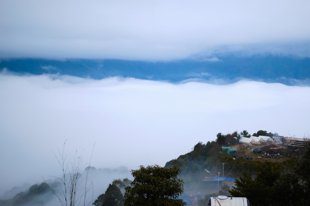 a foggy mountain with a tent in the foreground