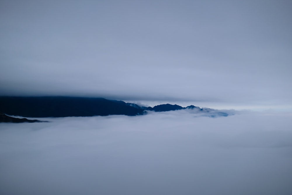 a foggy sky with mountains in the distance