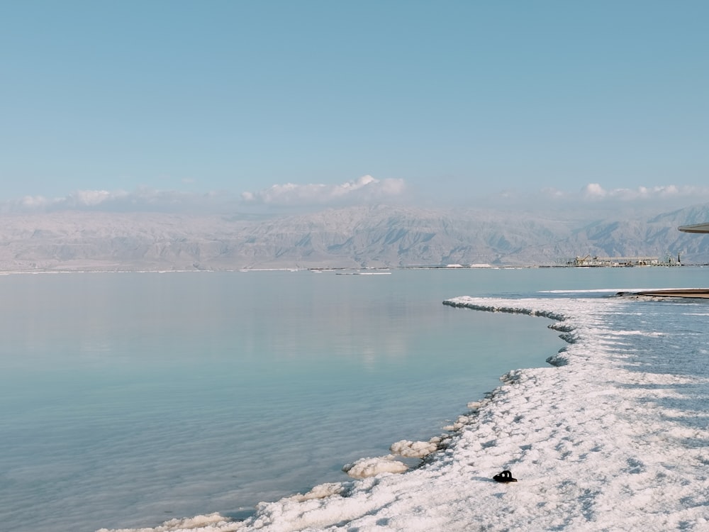 a body of water surrounded by snow and mountains