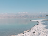 a body of water surrounded by snow and mountains