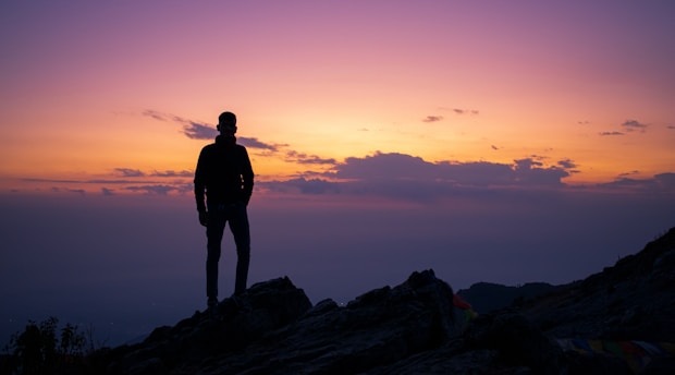 A vibrant photo of a climber silhouetted against a fiery sunset on rugged Australian cliffs.