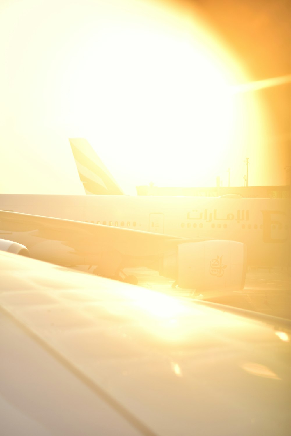 the sun is setting behind an airplane on the tarmac