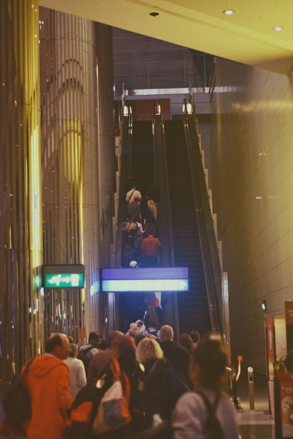 한 무리의 사람들이 에스컬레이터를 걷고 있습니다.
