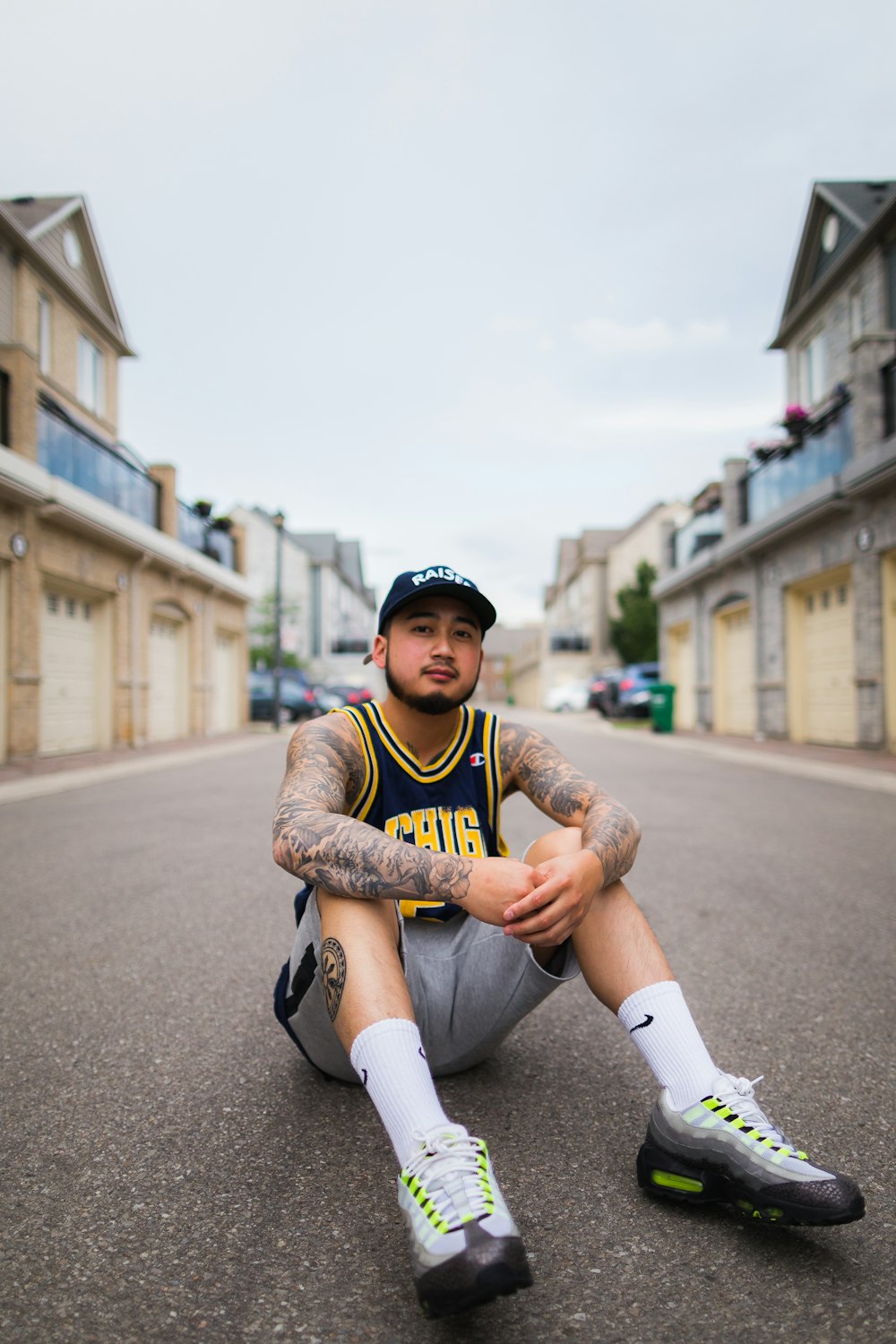 a man with tattoos sitting on the street