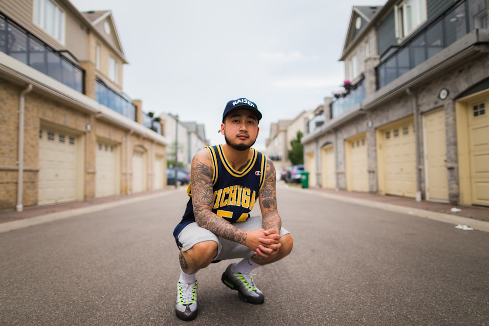 a basketball player squatting down in the middle of a street