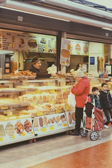 a group of people standing in front of a doughnut shop