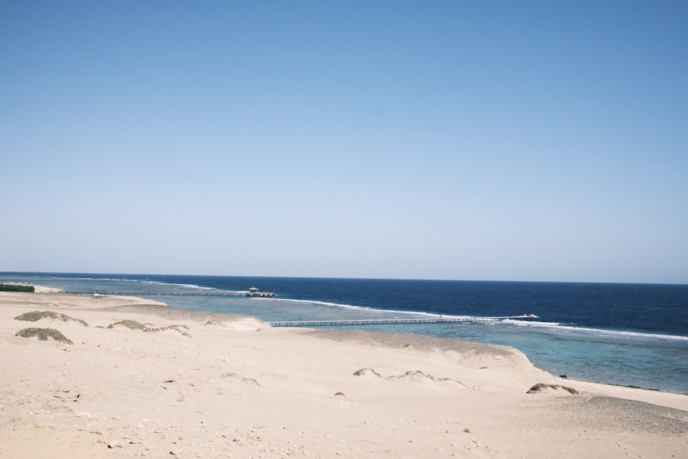 a sandy beach next to a body of water