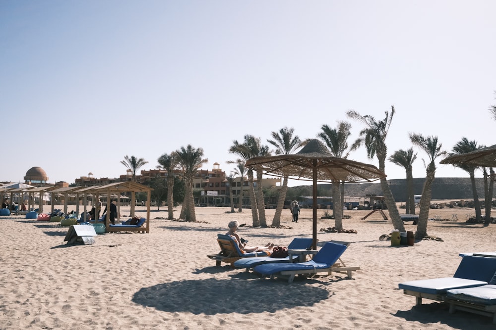 a sandy beach with lounge chairs and umbrellas