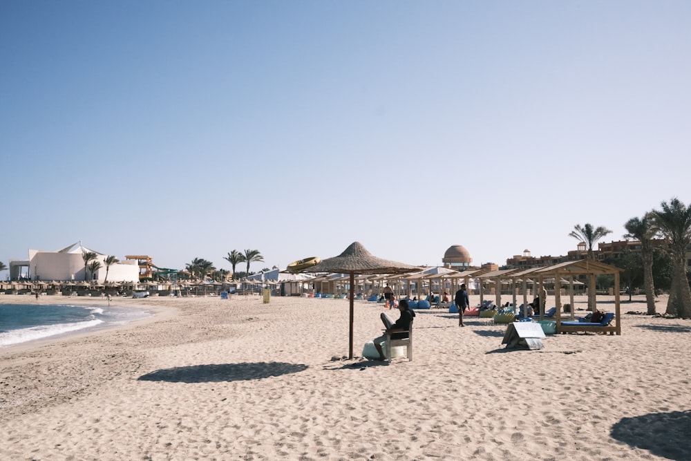 ein Sandstrand mit Sonnenschirmen und Liegestühlen