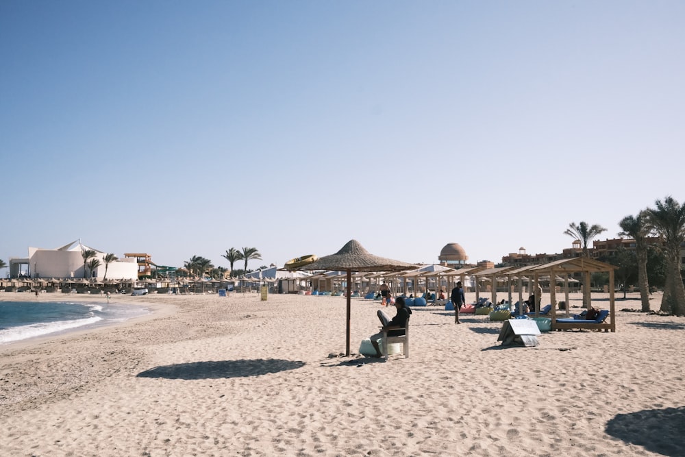 a sandy beach with umbrellas and lounge chairs