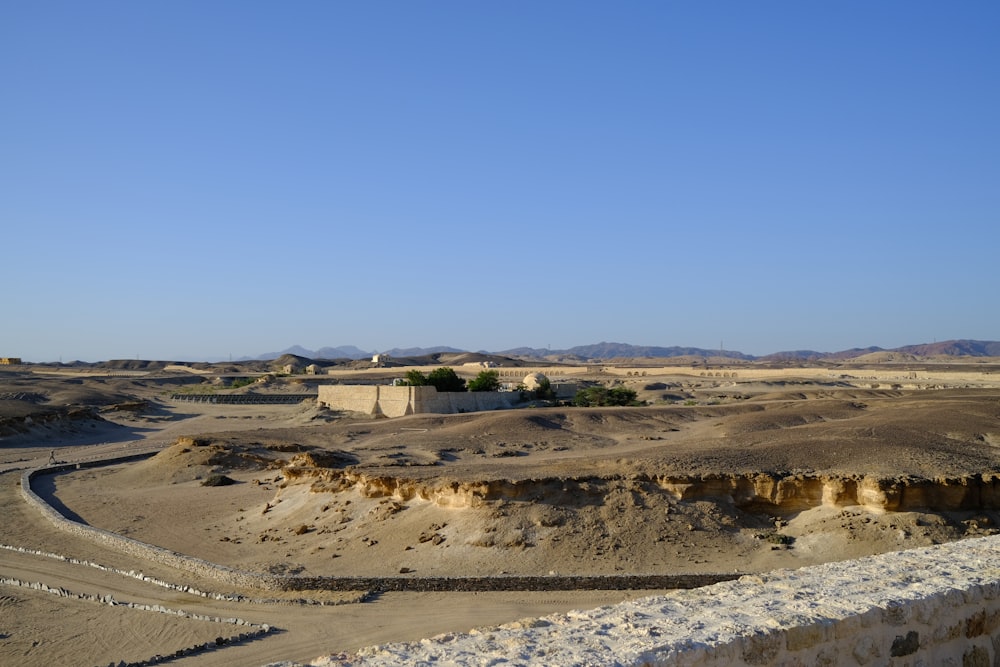 a view of a desert with a building in the distance