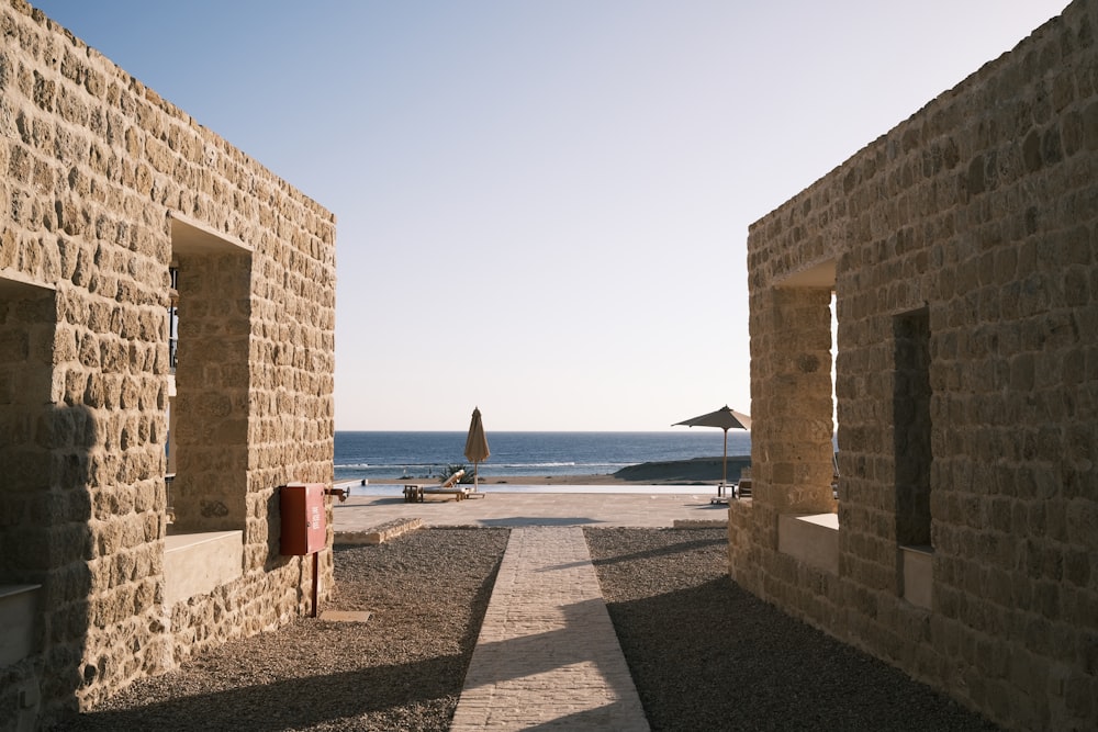 Ein Steingebäude neben dem Meer mit einem Strand im Hintergrund