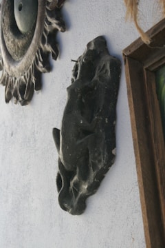 Abstract metal wall decor with a rustic bronze finish hanging on a white wall.