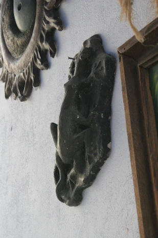 Decorative wooden and metal wall art piece inspired by organic shapes, mounted on a textured neutral wall.