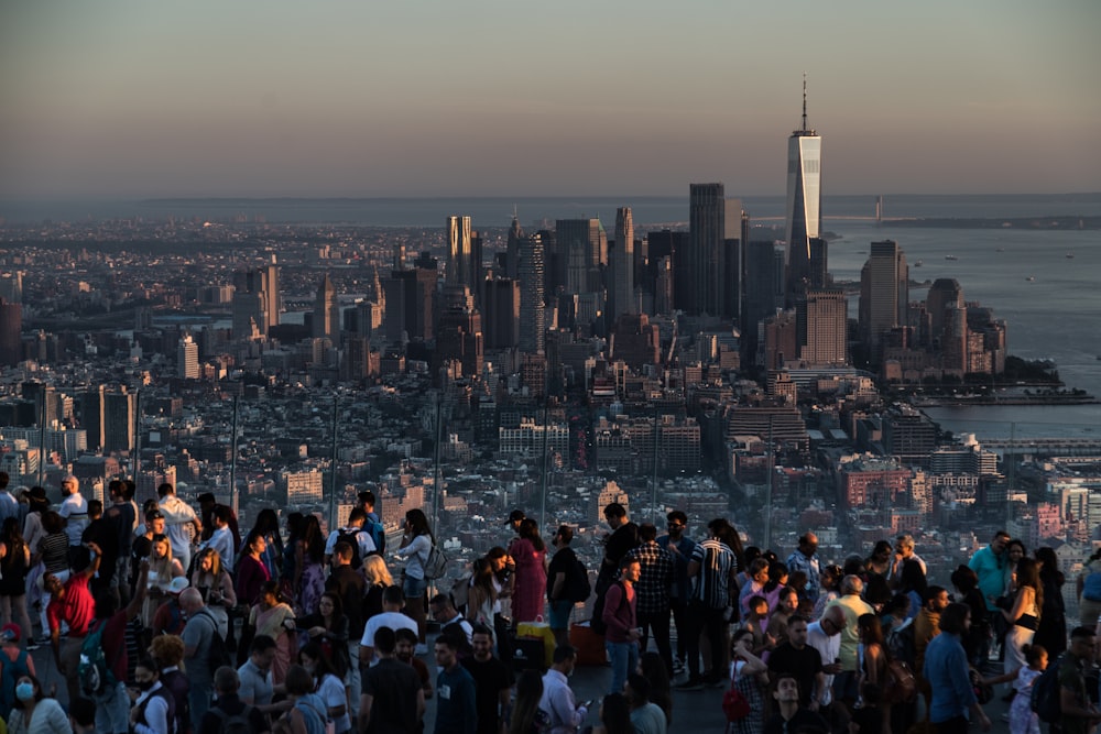 a large group of people standing in front of a city