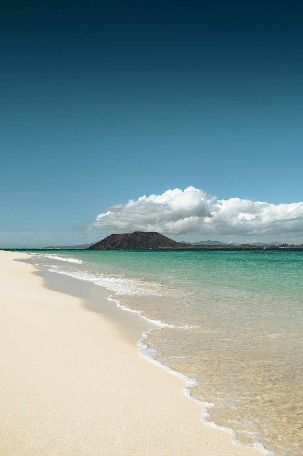 una spiaggia di sabbia con una montagna in lontananza