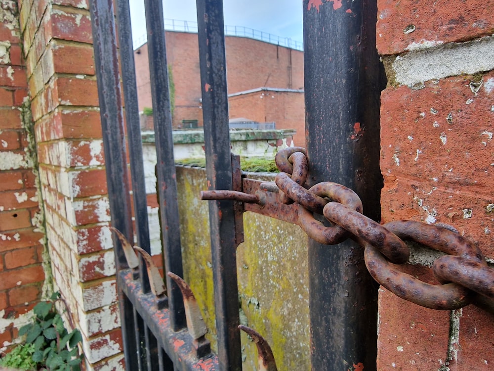 a rusted iron gate with a chain hanging from it
