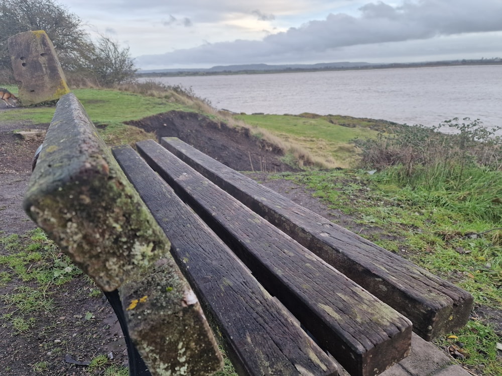 a wooden bench sitting next to a body of water